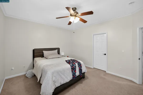 a bedroom with a bed and a ceiling fan