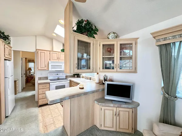 a large white kitchen with a stove a sink and a refrigerator