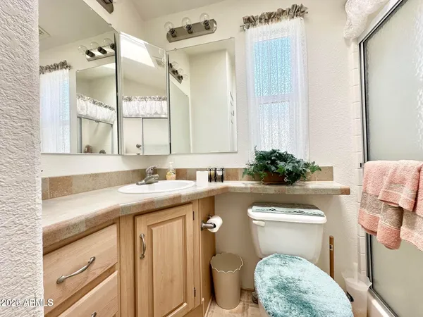 a bathroom with a granite countertop toilet sink and mirror