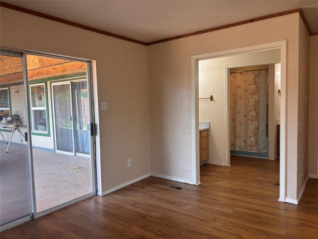 5355 Banks Road Fort Worth, TX 76140 - Photo 23 of 29 an empty room with wooden floor and a hallway