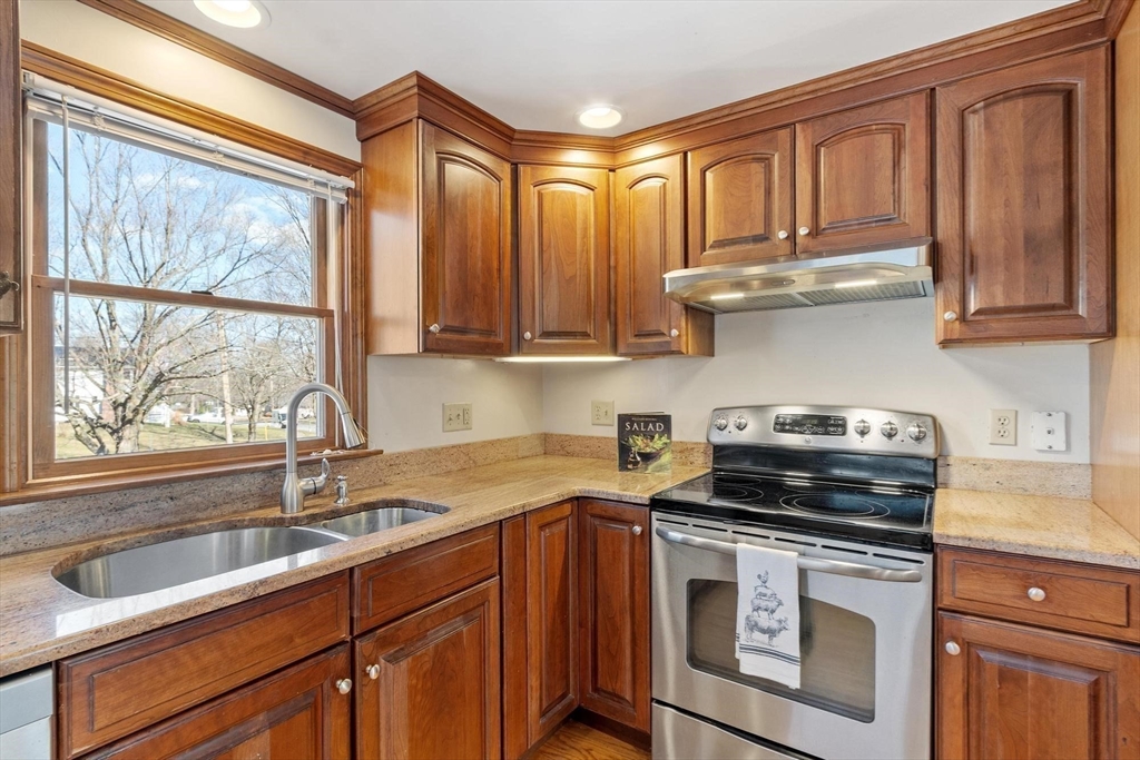 26 Lothrop Road Reading, MA 01867 - Photo 13 of 41 a kitchen with stainless steel appliances granite countertop a sink a stove and a microwave