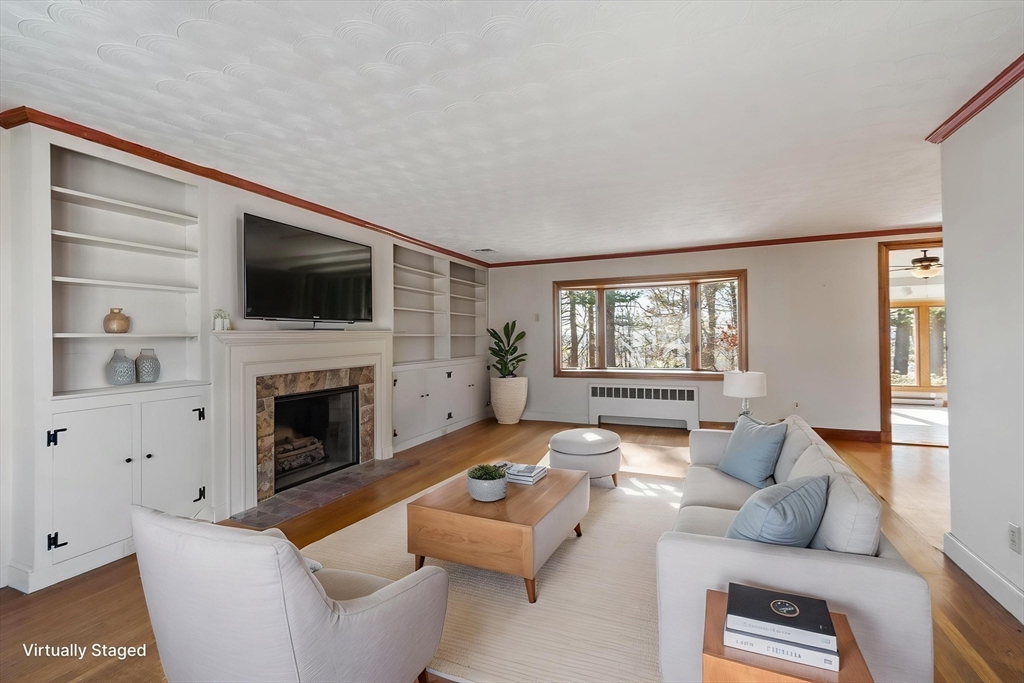 26 Lothrop Road Reading, MA 01867 - Photo 18 of 41 a living room with furniture a fireplace and a flat screen tv