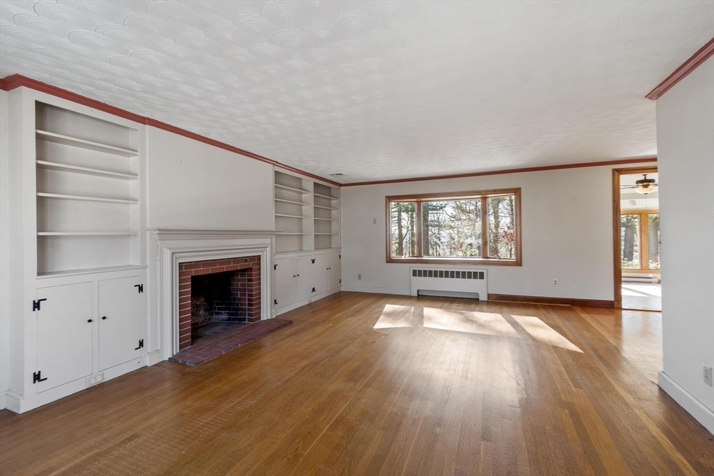 26 Lothrop Road Reading, MA 01867 - Photo 19 of 41 a view of empty room with wooden floor and fireplace