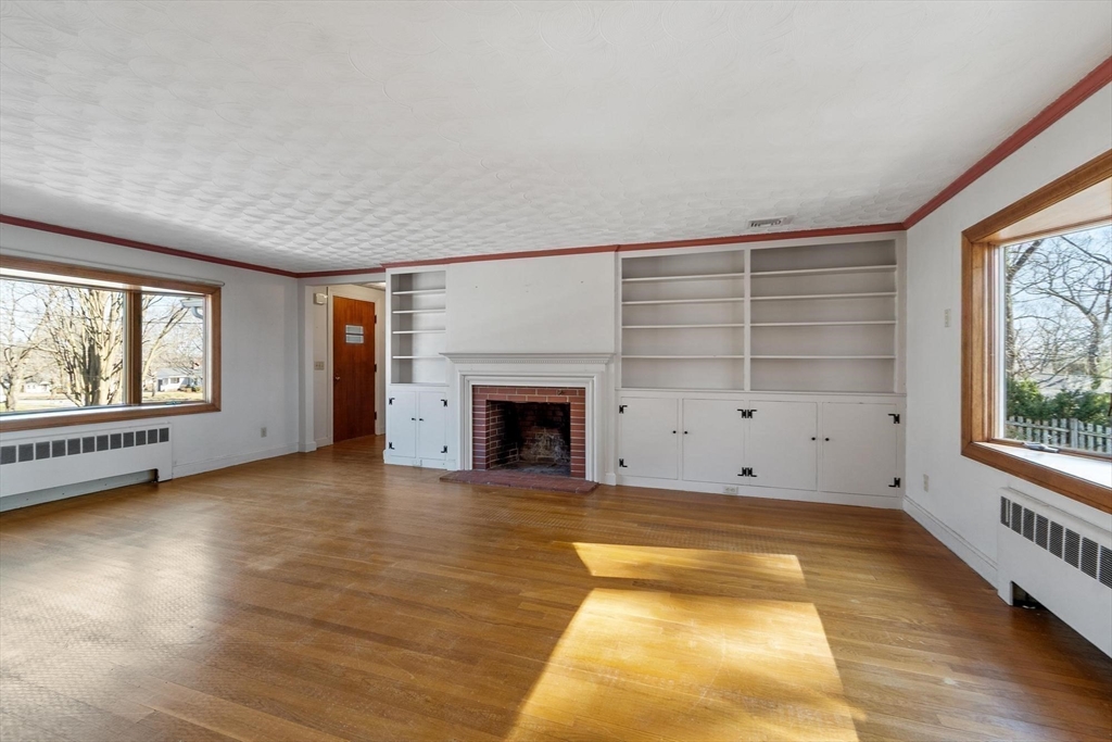 26 Lothrop Road Reading, MA 01867 - Photo 20 of 41 a view of an empty room with a window and wooden floor