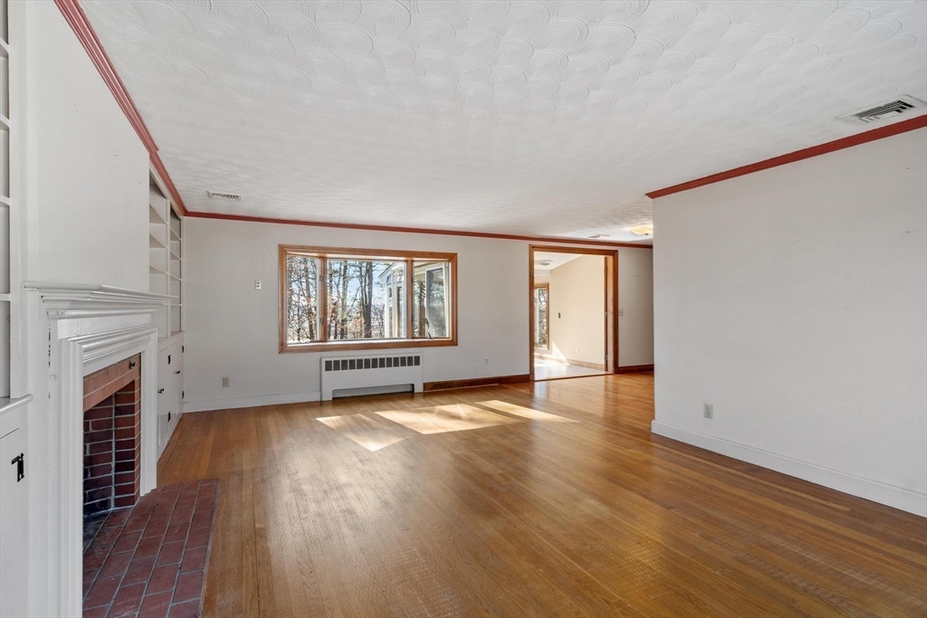 26 Lothrop Road Reading, MA 01867 - Photo 21 of 41 a view of an empty room with wooden floor and a window