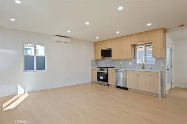 a large kitchen with granite countertop a sink and cabinets
