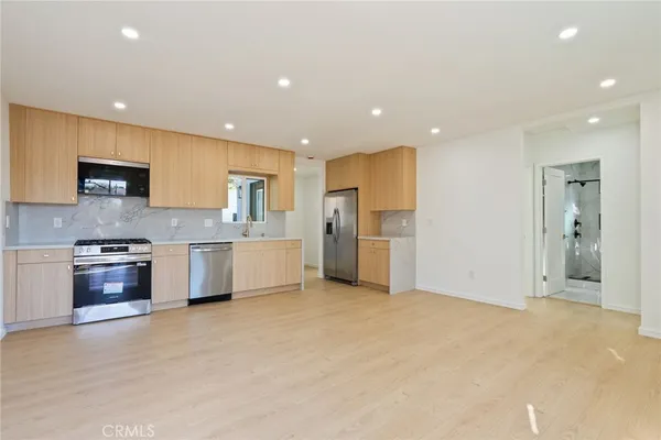a large kitchen with stainless steel appliances granite countertop a stove a sink and a refrigerator