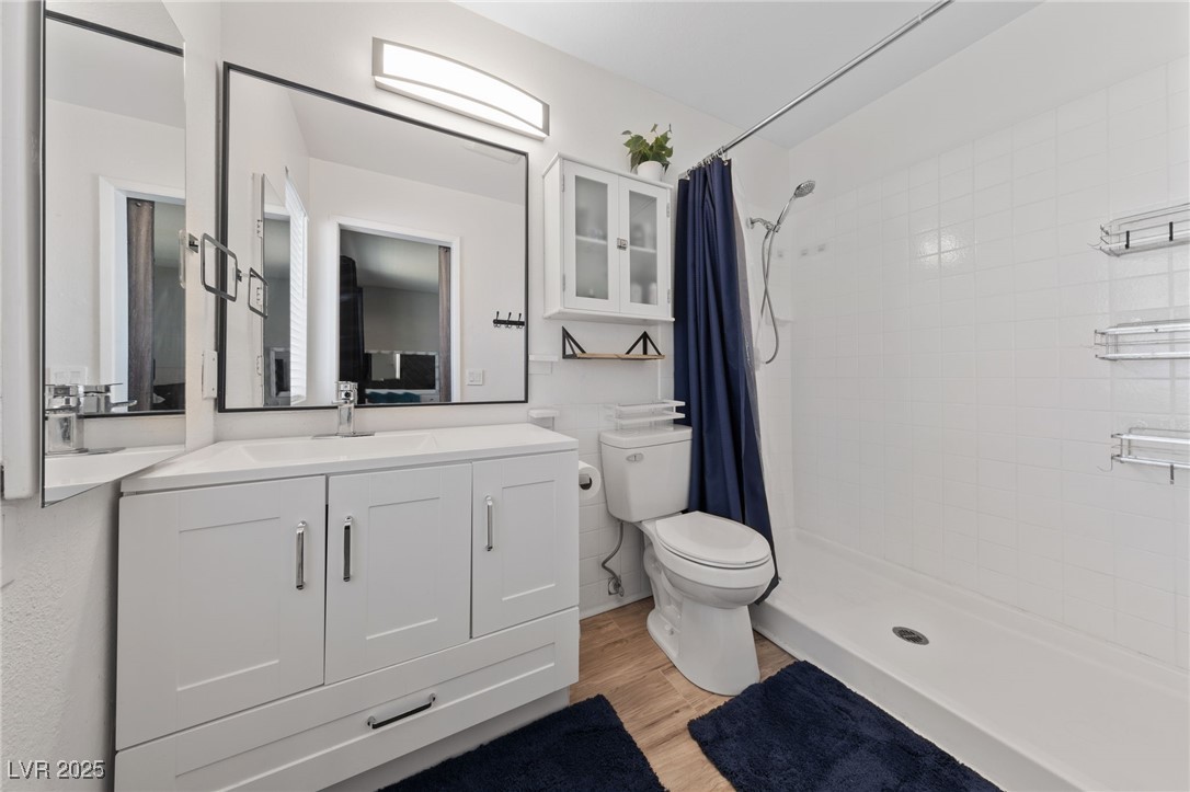 2637 Rialto Road Las Vegas, NV 89108 - Photo 11 of 22 Bathroom featuring toilet, a stall shower, wood finished floors, and vanity