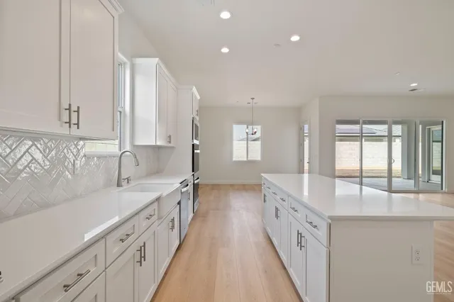 a large white kitchen with cabinets and a sink