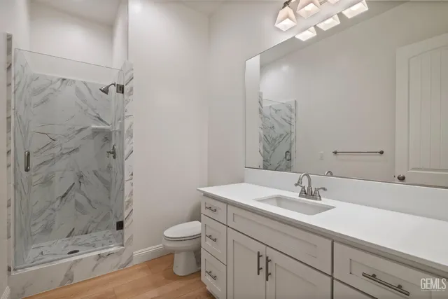 a bathroom with a sink a toilet and shower