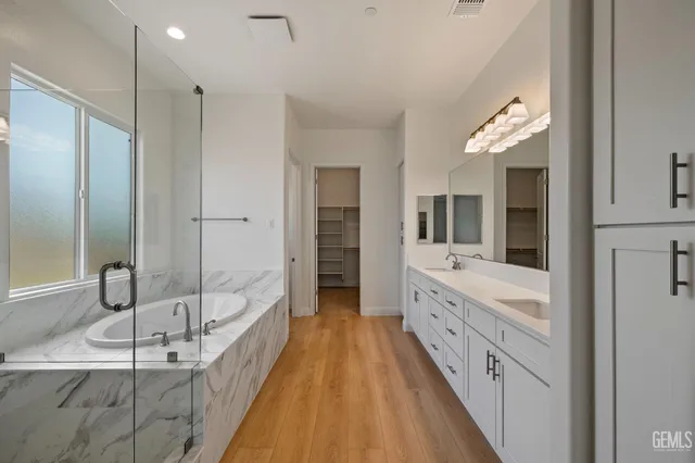 a spacious bathroom with a double vanity sink and a large mirror