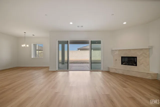 an empty room with wooden floor and fireplace