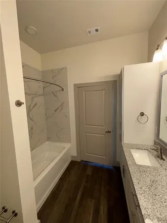 a bathroom with a granite countertop sink toilet and shower