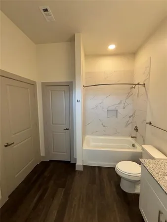 a bathroom with a granite countertop toilet a sink and bathtub