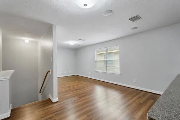 a view of empty room with wooden floor and fireplace