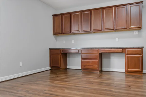 an empty room with wooden floor and entrance