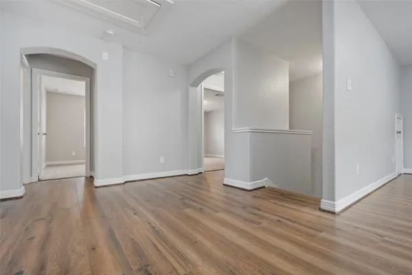 a view of an empty room with wooden floor and closet