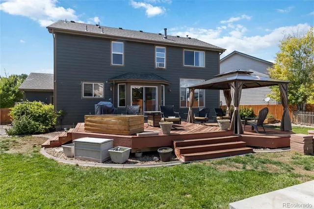 a front view of a house with garden and sitting area