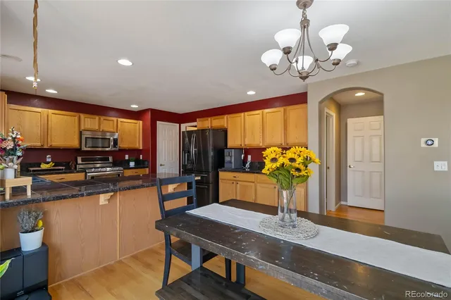 a view of a dining room with furniture a chandelier and wooden floor