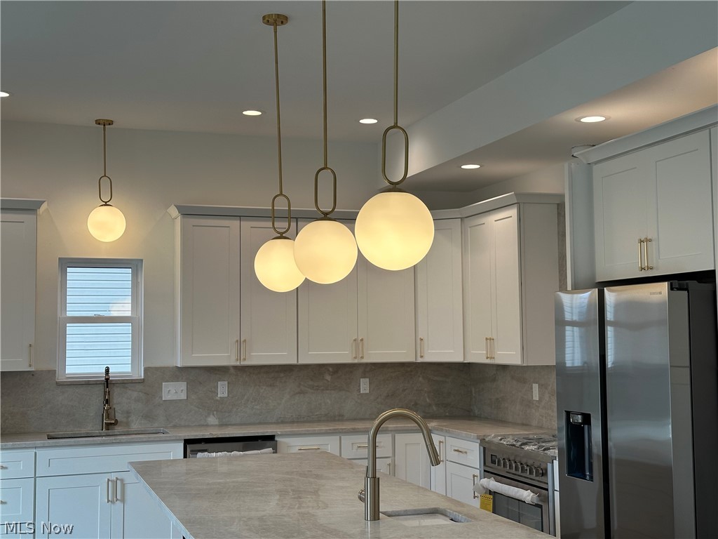 316 Miner Road Cleveland, OH 44143 - Photo 12 of 35 Kitchen with appliances with stainless steel finishes, sink, tasteful backsplash, and pendant lighting