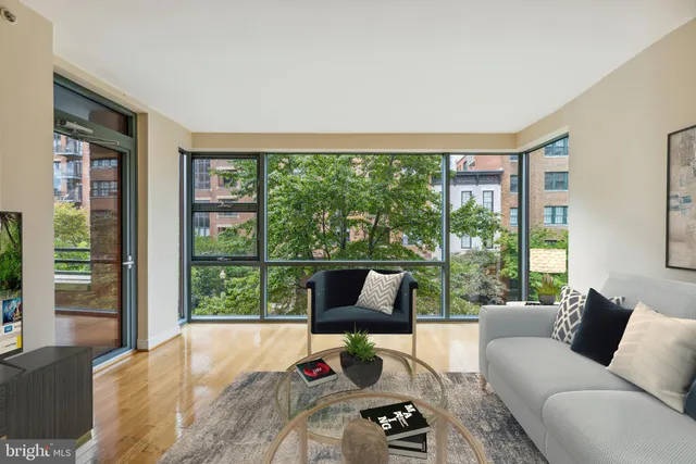 a living room with furniture and a floor to ceiling window