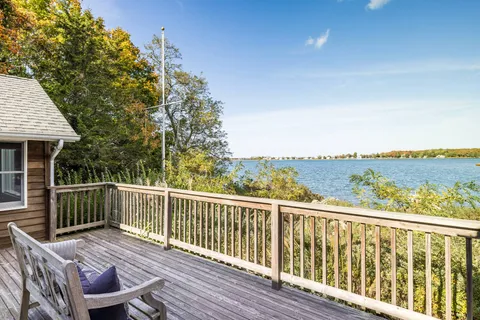 a view of a wooden deck with two chairs and wooden fence