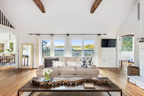 a living room with furniture wooden floor and a large window