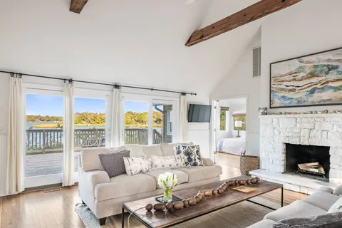 a living room with furniture a fireplace and a floor to ceiling window