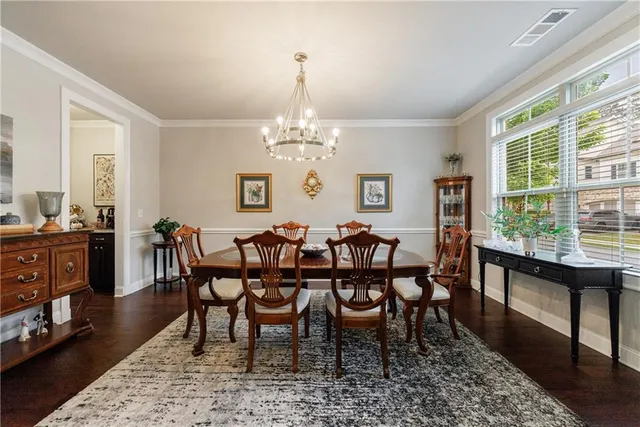 a kitchen with granite countertop a table chairs stainless steel appliances and wooden floor