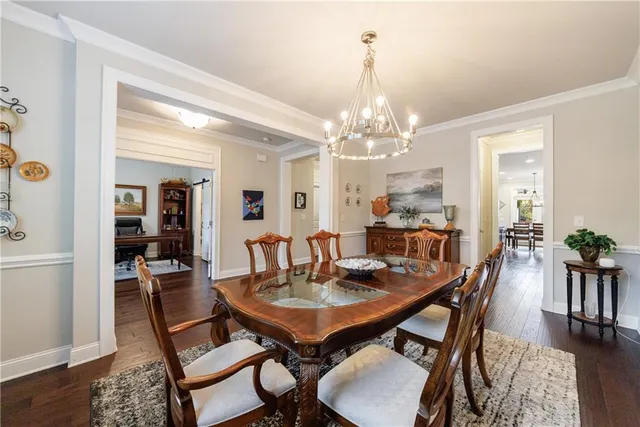 a dining room with furniture a chandelier and wooden floor
