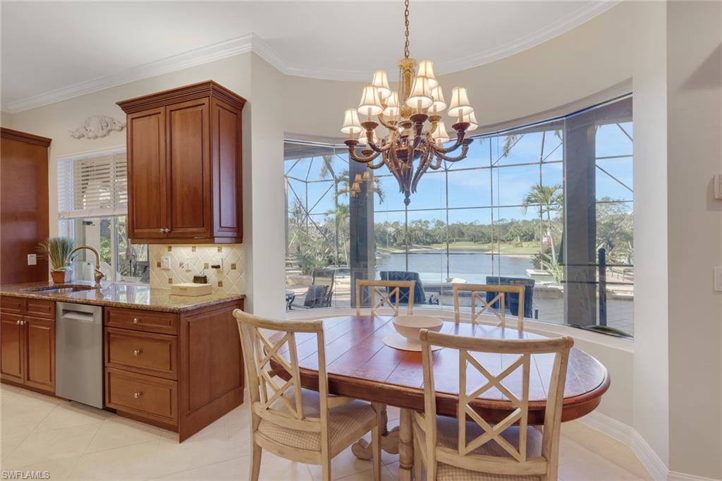 1859 Ivory Cane Point Naples, FL 34119 - Photo 16 of 50 Dining space featuring ornamental molding, a chandelier, light tile patterned flooring, and a water view