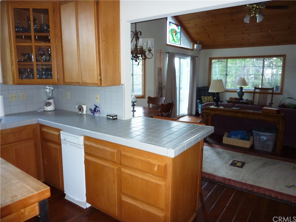 25274 N Road Twin Peaks, CA 92391 - Photo 12 of 35 a kitchen with kitchen island granite countertop a sink cabinets and wooden floor