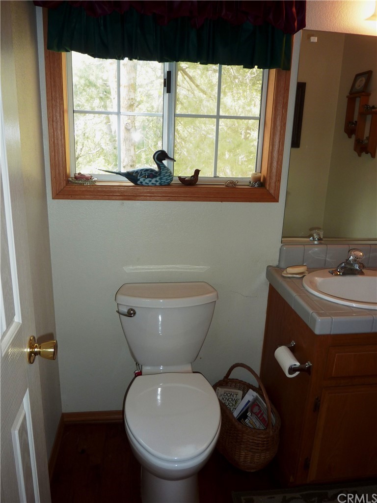 25274 N Road Twin Peaks, CA 92391 - Photo 15 of 35 a bathroom with a toilet sink and window
