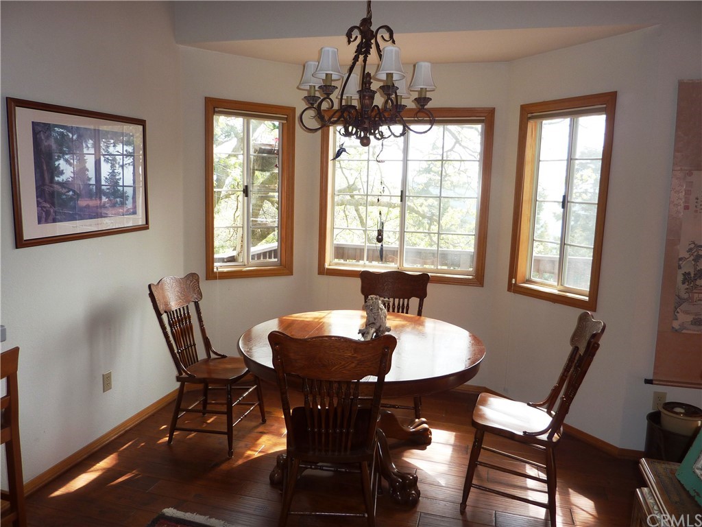 25274 N Road Twin Peaks, CA 92391 - Photo 6 of 35 a view of a dining room with furniture a chandelier and wooden floor