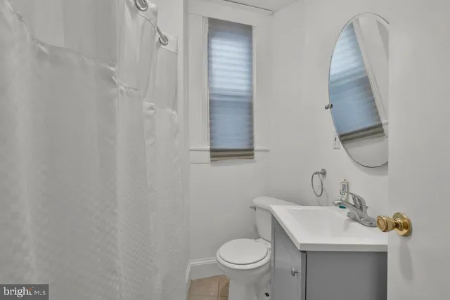 a bathroom with a toilet a sink and a window