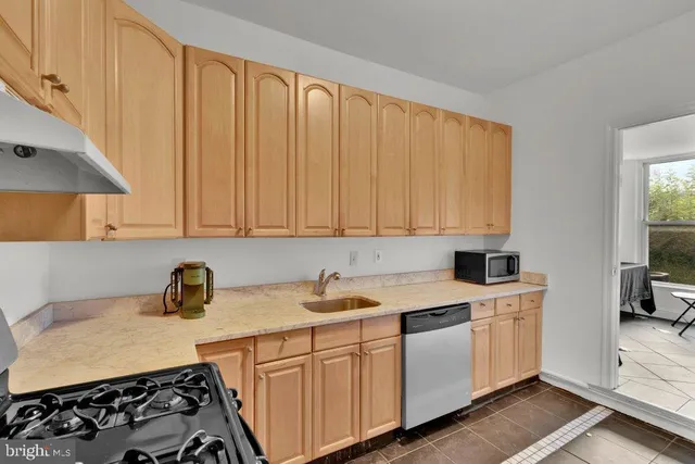 a kitchen with granite countertop a sink a stove and cabinets