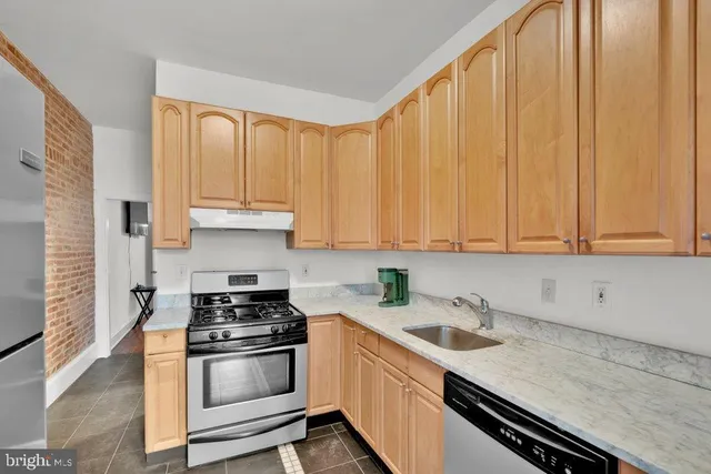 a kitchen with granite countertop a sink a stove and cabinets
