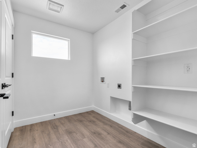 1380 West 2350 South, Unit 16 Perry, UT 84302 - Photo 26 of 34 Dedicated utility space featuring built-in shelving, wood-finish flooring, and a rectangular window