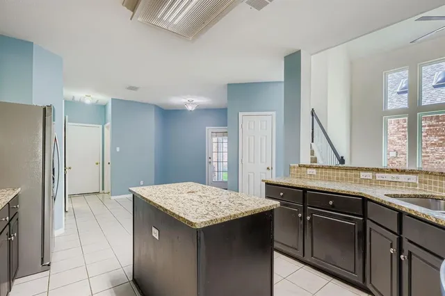 a large kitchen with stainless steel appliances granite countertop a refrigerator and a stove top oven