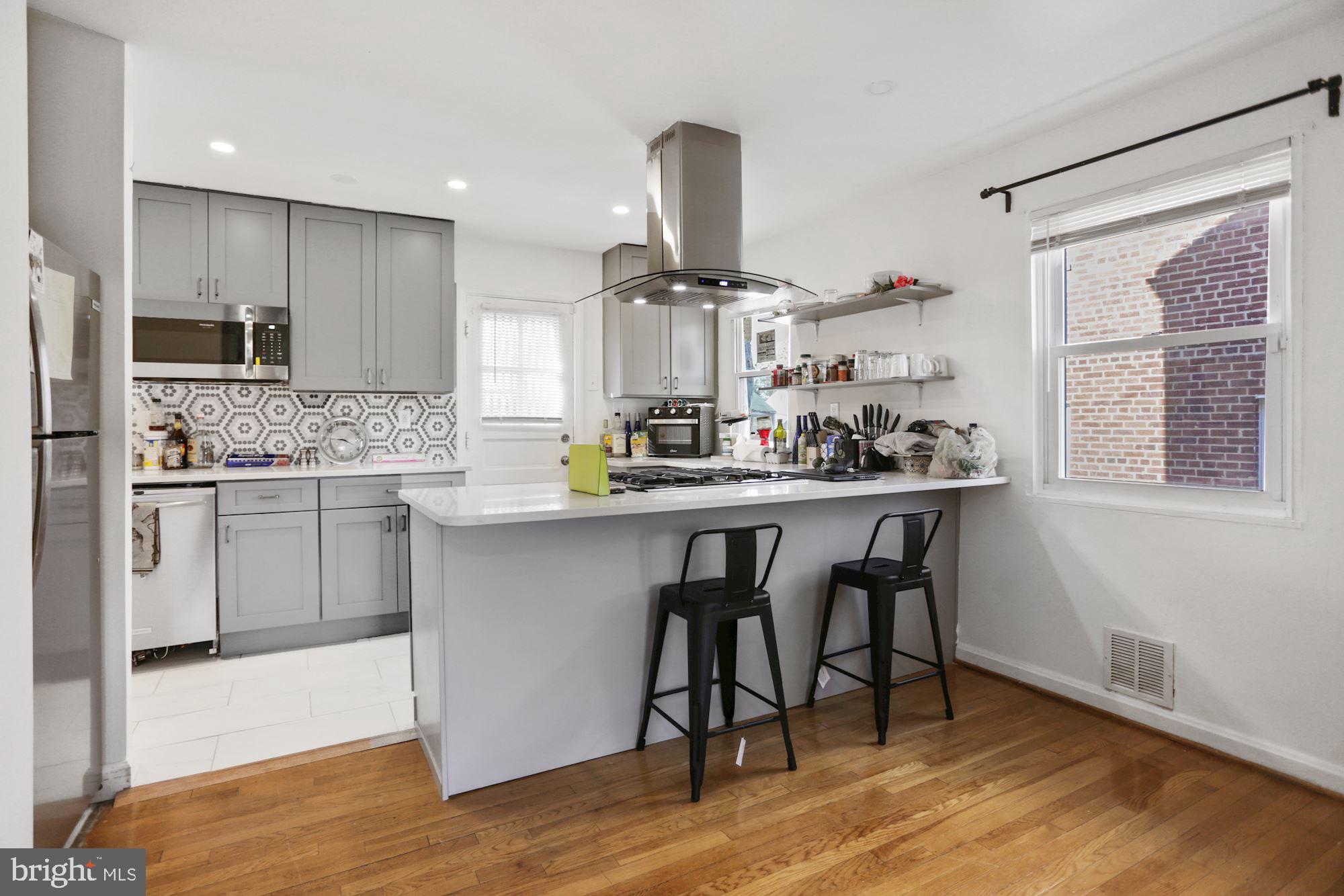 4910 Sargent Road Northeast Washington, DC 20017 - Photo 3 of 16 a kitchen with a table chairs stove and cabinets