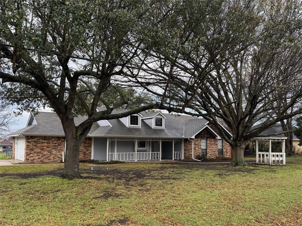 a front view of a house with a garden and trees