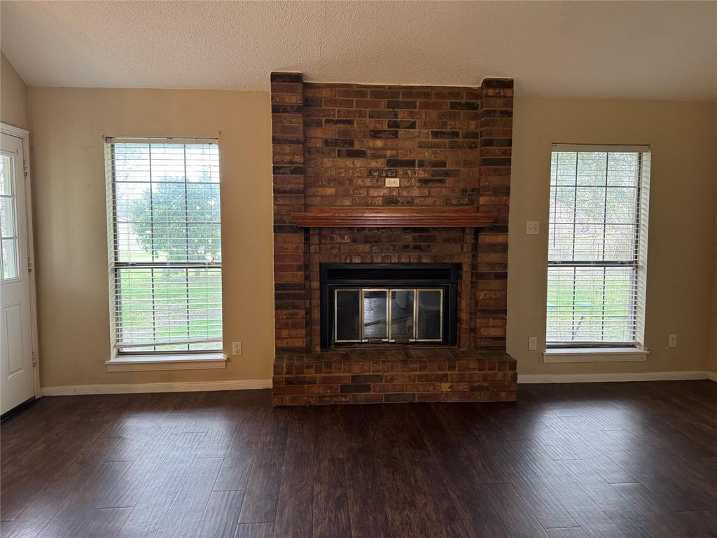 116 Ridge Crest Street Red Oak, TX 75154 - Photo 6 of 18 an empty room with wooden floor fireplace and windows