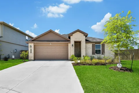 a front view of a house with a garden and yard