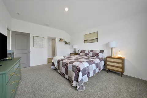 a spacious bedroom with a bed and a flat screen tv