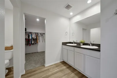 a bathroom with double vanity and a mirror