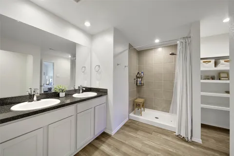 a spacious bathroom with double sink and shower