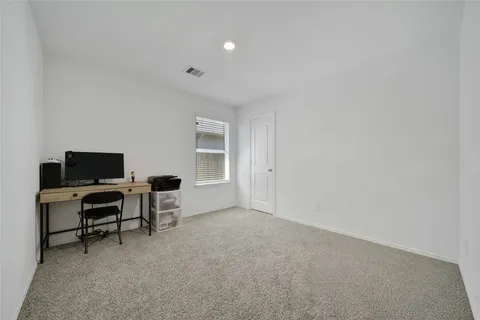 a view of a livingroom with workspace and a window