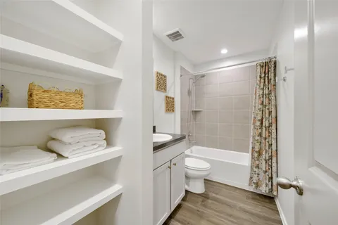 a bathroom with a granite countertop sink toilet a mirror a bathtub and shower