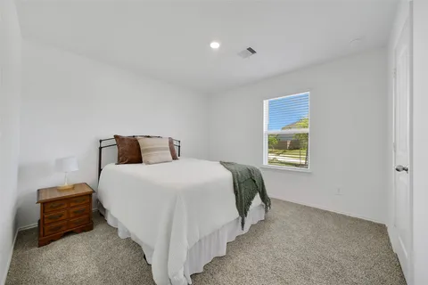 a bedroom with a bed and a lamp