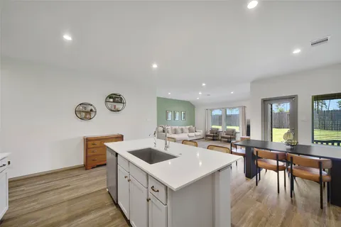 a kitchen with a stove a refrigerator and a dining table with wooden floor